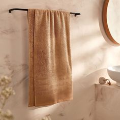 a tan towel hanging on a wall next to a sink