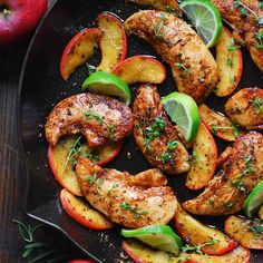 chicken, apples and limes on a black plate