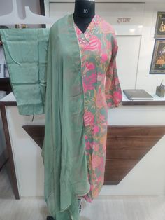 Embrace vibrant style with this stunning Kurti, Pant and Dupatta Set. The set comes with Muslin Kurti, Silk Pant and Chiffon Dupatta. The kurti looks simply gorgeous and the comfortable pants and flowy dupatta complete the look, making it perfect for any ocassion. Festive Multicolor Semi-stitched Lawn Suit, Festive Green Unstitched Suit With Printed Motifs, Spring Wedding Multicolor Palazzo Set, Green Chanderi Salwar Kameez With Printed Motifs, Green Salwar Kameez With Printed Motifs, Green Lawn Suit With Printed Motifs For Festivals, Festive Green Pant Set With Resham Embroidery, Fitted Green Pant Set For Wedding, Green Fitted Pant Set For Wedding