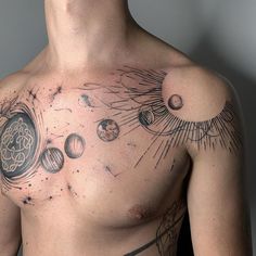 a man with tattoos on his chest is looking at the sky and planets around him