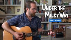 a man playing an acoustic guitar with the words under the milky way