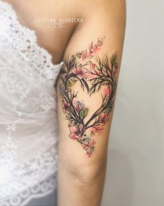 a woman with a heart shaped tattoo on her arm