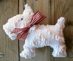 a white stuffed dog with a red checkered bow