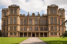 a large brown building with lots of windows on it's sides and a walkway leading to the front door