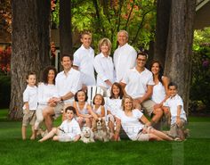 a group of people and a dog posing for a photo in front of some trees