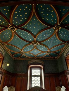 an ornate room with wooden paneling and blue ceiling painted with gold stars on the ceiling