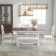 a dining room table with white chairs and a vase on top of it in front of a window