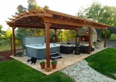 a hot tub sitting under a wooden pergoline covered gazebo in a backyard