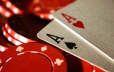 playing cards and casino chips on a table with red lights in the backround