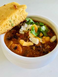 a white bowl filled with soup next to a piece of bread