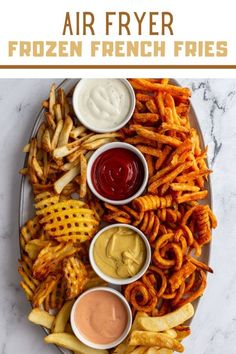 an air fryer with french fries and dipping sauces