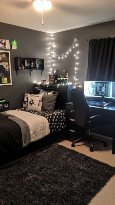 a bedroom decorated in black and white with lights strung from the ceiling, bedding, rugs and desk