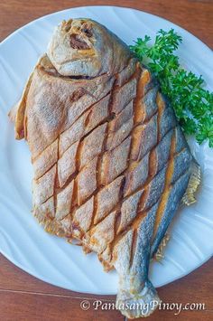 a piece of fish sitting on top of a white plate next to some parsley