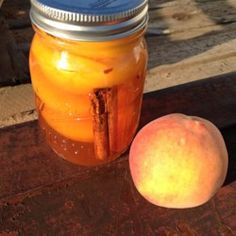 an apple sitting next to a mason jar on a wooden table with the lid open