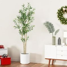 a living room decorated for christmas with wreaths on the wall and two potted plants