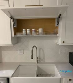 a kitchen with white cabinets and an empty sink