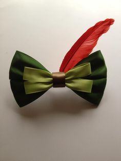 a green bow tie with a red feather on it