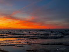 the sun is setting over the ocean with clouds in the sky