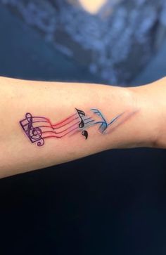 colorful musical notes tattoo on the arm