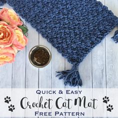 the crochet cat mat is next to some flowers