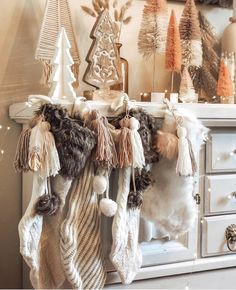 christmas stockings hanging from a fireplace mantle with pom - poms and tassels