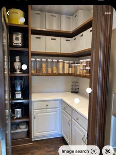 an open pantry with white cabinets and drawers