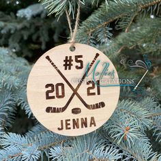 a wooden ornament hanging from a tree with hockey sticks and pucks on it