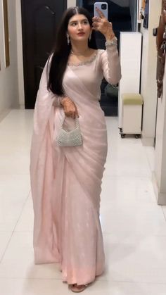 a woman in a pink sari taking a selfie