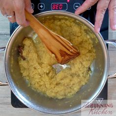 a person stirring food in a pot with a wooden spoon