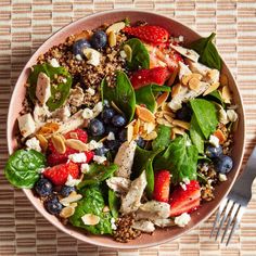 a salad with spinach, strawberries, blueberries and almonds in a bowl