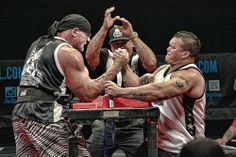 two men wrestling each other in a ring with one man holding the other's hand