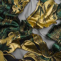 gold and green fabric with large leaves on the bottom, as well as other material