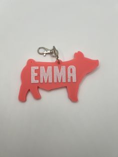 a keychain shaped like a pig with the word emma printed on it