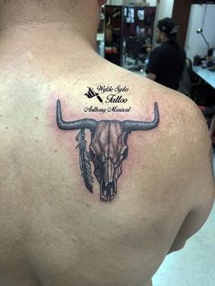 a man with a bull skull tattoo on his back