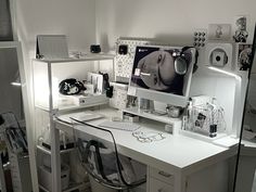 a white desk with a computer on top of it and other items around the table