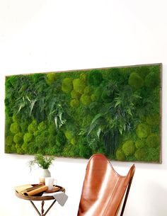 a chair and table in front of a moss wall