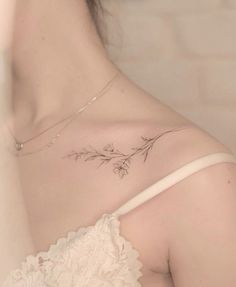 the back of a woman's shoulder with flowers and leaves on her left side