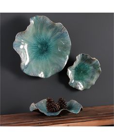 two decorative dishes on a table with pine cones