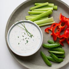 a plate filled with celery, peppers and dip