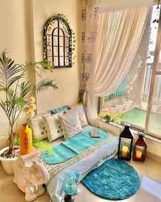 a bed room with a neatly made bed next to a window and a potted plant