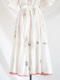 Immerse yourself in sustainable elegance with our upcycled cotton and linen maxi dress. The square neck and half ruffle sleeves, adorned with peach fabric and lace detailing, offer bohemian sophistication. Hand-embroidered colorful floral motifs on a white canvas, coupled with see-through lace details, create a timeless fashion statement.   The tiered flared hemline features subtle floral embroidery, a blanket stitch border, and delicate lace for a whimsical touch. Complete with a back zipper and adjustable bow tie for effortless style. Care: Cool machine wash. Dry at a lower heat and press with a medium iron.  Condition: Embrace the distinctive charm of this upcycled treasure, where imperfections are unique features. Delight in the occasional loose thread or subtle discoloration, each add Sleeved Maxi Dress, Peach Fabric, Bohemian Floral, Linen Maxi Dress, Blanket Stitch, Unique Features, Ruffle Sleeves, Maxi Dress With Sleeves, Floral Motifs