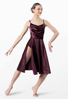 a woman in a purple dress is posing for the camera with her legs spread out