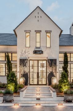 a large white house with lots of windows and steps leading up to the front door