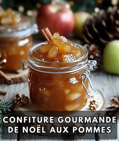 a jar filled with fruit sitting on top of a wooden table next to pine cones