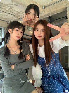 three young women posing for the camera in front of a mirror