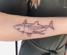 a shark with a party hat on it's head is tattooed onto the arm