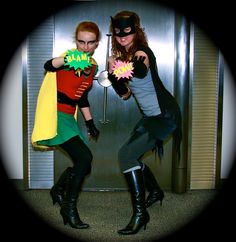 two women dressed as batman and robin wayne posing for a photo in front of an elevator