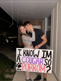 a man and woman standing next to each other holding a sign that says i know i'm a cougar so purim