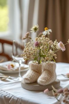 there is a vase with some flowers in it on the table next to a pair of shoes