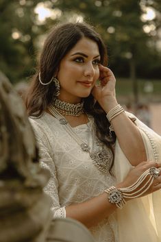 The Sanzida Silver & Pearl Full Bridal Set is an exquisite, handcrafted collection designed for the perfect South Asian wedding. This bridal set includes a choker necklace set, long haar, maang tikka, jhoomer, and two haathphool with attached rings. Made from silver plating, this stunning bridal jewelry features zircon stones in white and a clear grayish center stone, complemented by cascading faux pearls. Ideal for Pakistani jewelry enthusiasts, this bridal set is a must-have for any bride. Key Silver Kundan Set For Eid, Silver Cutdana Traditional Wear For Reception, Silver Anarkali Set For Eid Reception, Traditional Silver Sharara For Reception, Silver Traditional Wear With Cutdana For Reception, Elegant Hand Set Lehenga For Wedding, Elegant Wedding Sets For Navratri, Traditional Silver Sharara For Wedding, Traditional Silver Anarkali Set For Eid